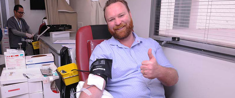 Nathan Heberley, WCM-Q’s software development manager, donates to the blood drive.