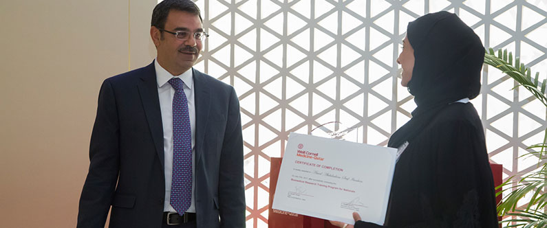 Dr. Khaled Machaca, Associate Dean for Research at WCM-Q, presents a certificate of graduation to one of the interns.