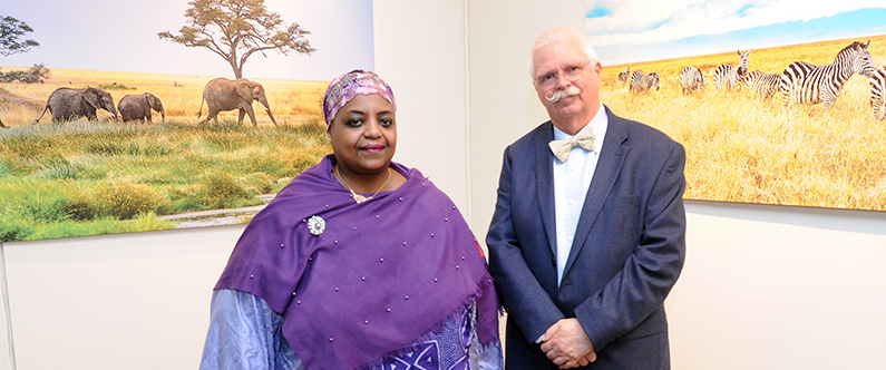 HE Ms Fatima Mohammed Rajab and Dr. Dietrich Büsselberg in front of two of his photographs.