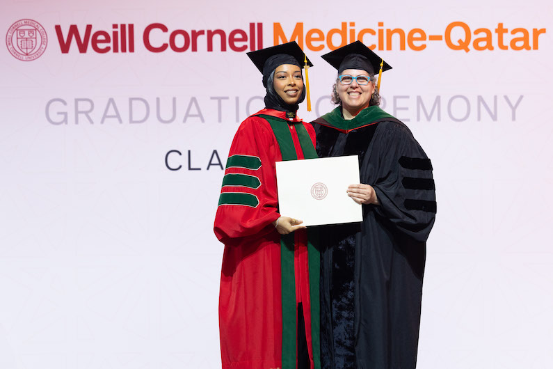 Dr. Moune Jabre presents class valedictorian Dr. Lina Ahmed with her diploma.