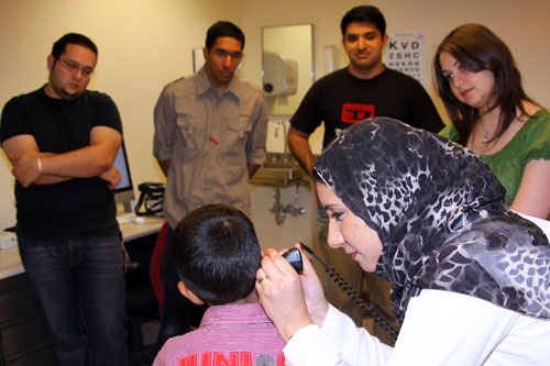 HMC pediatric resident Dr. Laila Mahmoud, foreground, models part of the physical exam on Dylan Serrao, 5, son of Diana Serrao in the Office of Curriculum Support, for third year medical students.