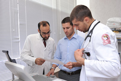 Students and doctor looking at cardiograph at Aspetar