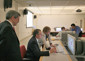 Gene Resnick tries out the virtual microscope system, guided by associate professor of pathology,
Dr. Powers Peterson, while Dean of WCMC-Q Dr. Daniel R. Alonso looks on.
