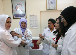 WCMC-Q pre-medical students Sumeja Zahirovic (second from left), Mahfam Shafaee (second from right) and HMC nurses prepare to administer the oral polio vaccine to a baby at Farik Abdul Aziz Vaccination Clinic.