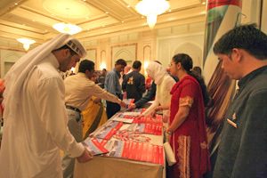 Crowds surround the WCMC-Q booth to talk to faculty and medical students.