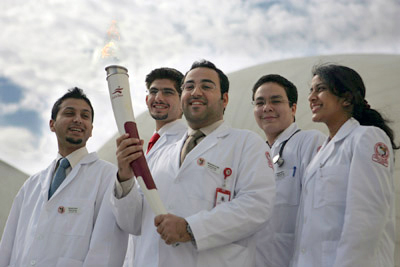 Qatari med student Mohammed Al Hijji stands holding the torch aloft alongside Naveed Anwar, Hassan Mohsen, Zuhair Salah and Shalini Ravishankar (Class of 2010)