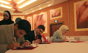 A night to remember: Beshoy Sidrak, Hassan Mohsen and Tala Rifai sign their name on class photographs.