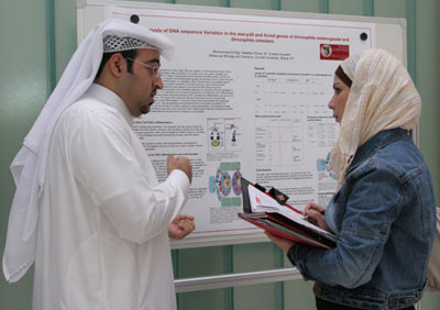 Qatari medical student Mohammed Al Hijji describes his genetics research to an invited guest at the Forum.