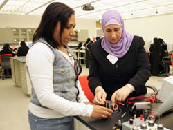Jaya Koshy (left) and Amal Kanan explore alternative current (AC) circuits at the fourth WCMC-Q physics workshops. The teachers are practicing physics skills they will use in interactive learning with students at Al-Bayyan Girl's School.