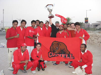 The WCMC-Q Cricket Tema celebrates their victory. Director of Student Affairs Eric Fry hoists the trophy.