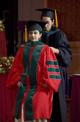 A "bittersweet" moment: Dr. Nounou Taleghani arranges the academic hood for Kunali Dalal.